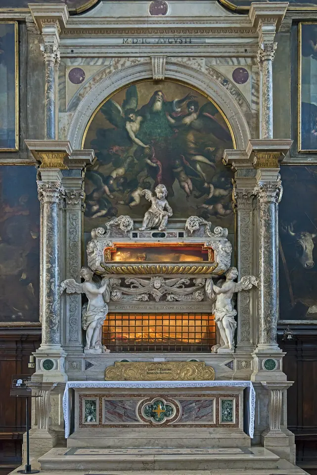 White marble Renaissance altar with a glass-fronted reliquary chest supported by carved angels, under a painted altarpiece