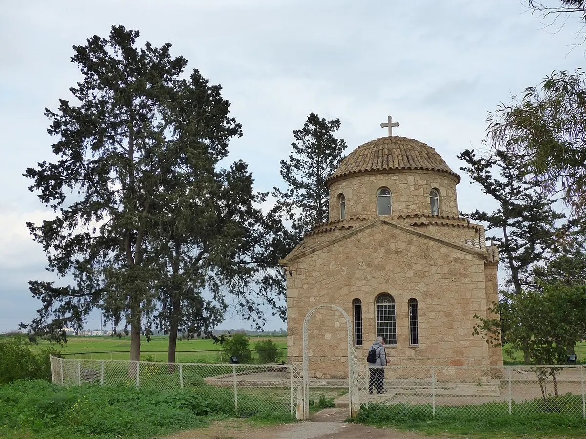 A small domed stone chapel among pine trees and fields, built over the tomb of St. Barnabas near the monastery