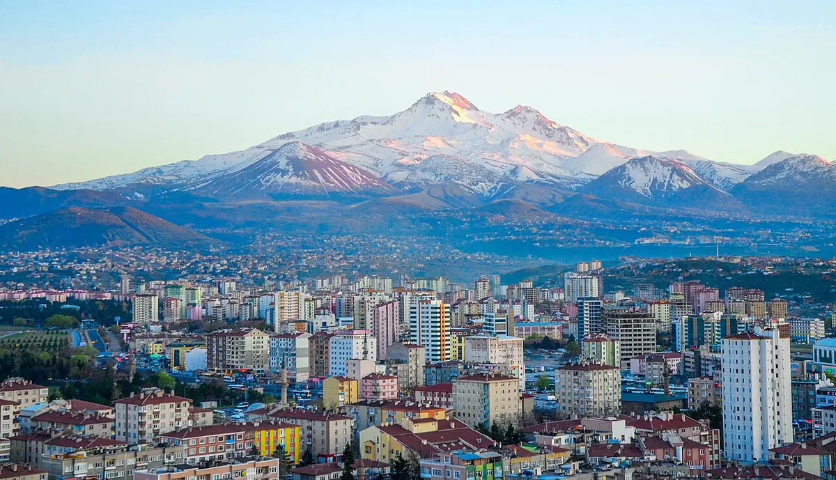 Snow-capped volcano rising above the apartment blocks of Kayseri under a clear sky
