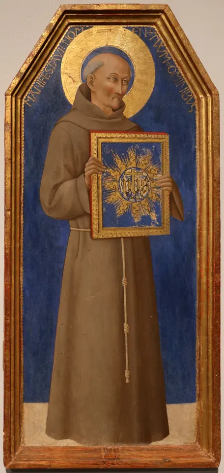 Gold-ground panel of a gaunt friar in a brown habit standing against a blue background and holding up a framed tablet with the golden IHS sun