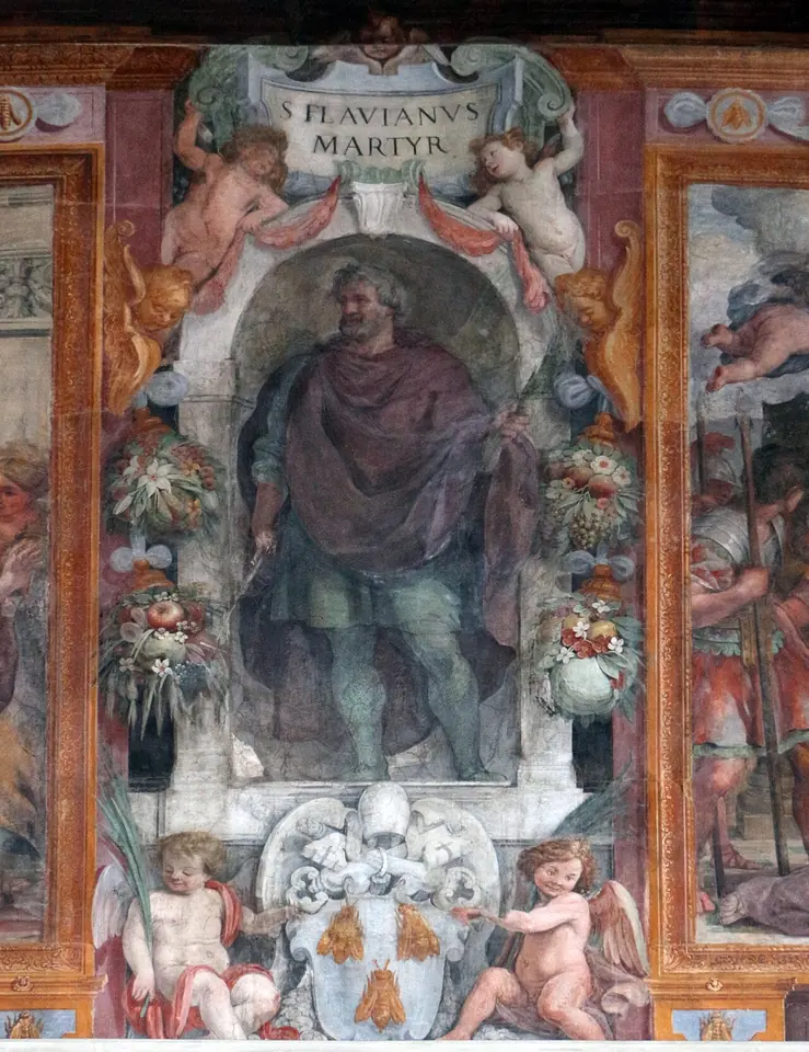 Fresco of a bearded Roman man in a red toga in a painted niche labeled S. Flavianus Martyr, framed by garlands and cherubs holding a papal coat of arms