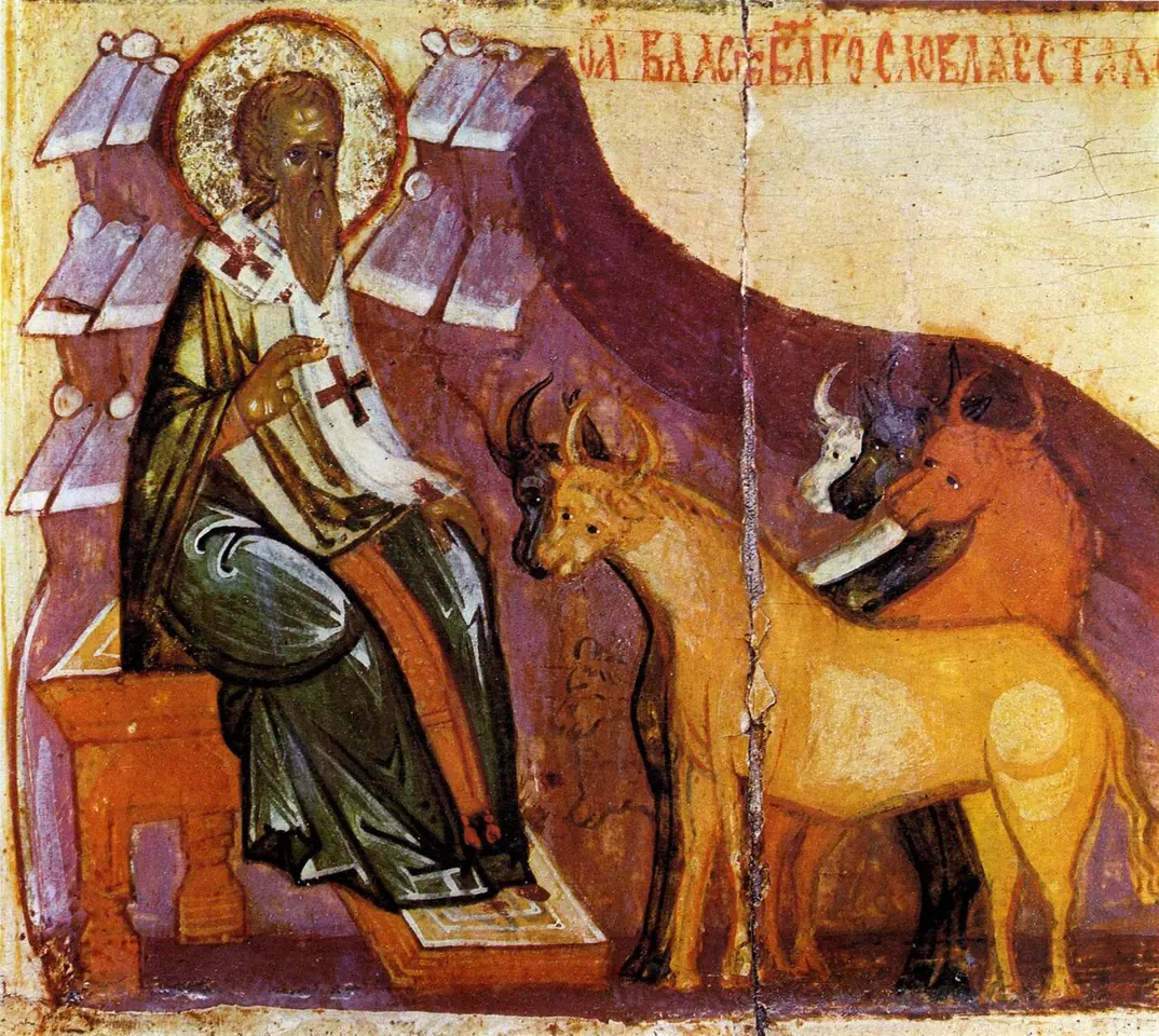 Russian icon fragment of St. Blaise seated before stylized rocky hills in bishop's vestments marked with red crosses, blessing horses and cattle gathered in front of him