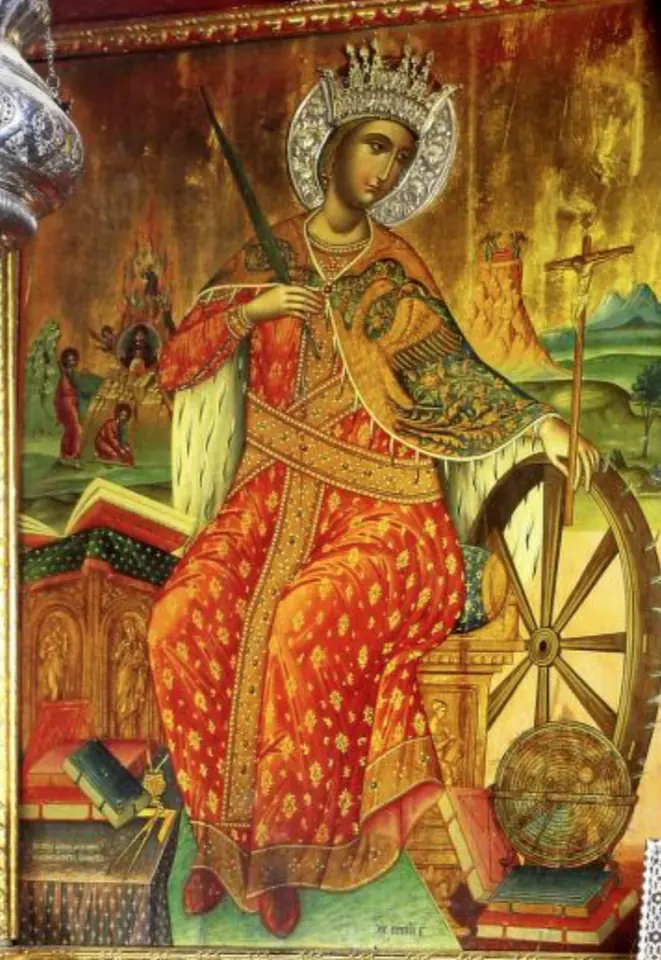 Cretan icon of St. Catherine enthroned in a jeweled crown and red and gold robes, holding a palm, her hand resting on a crucifix staff beside a large spiked wheel, with books, a pair of dividers and an armillary sphere at her feet and the burning bush of Sinai behind her