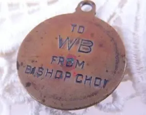 The plain back of the same bronze medal, hand-stamped with the words To WB From Bishop Choi