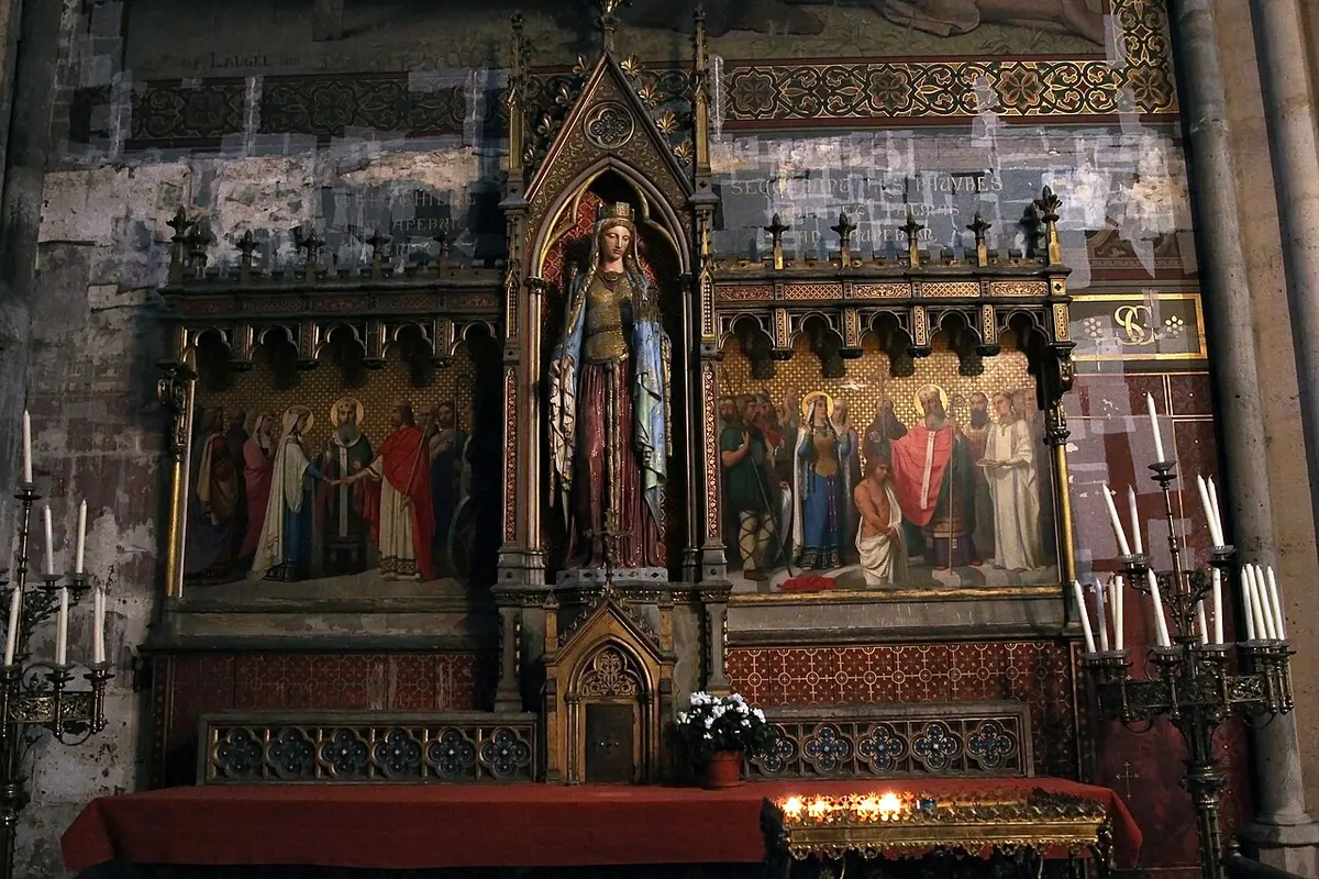 Gothic Revival altar with a painted statue of St. Clotilde in a pinnacled niche, flanked by painted panels of her marriage and the baptism of Clovis