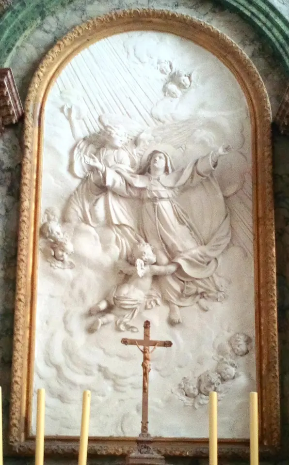 White marble relief in an arched gilded frame showing St. Colette carried up to heaven by angels, with a crucifix on the altar below