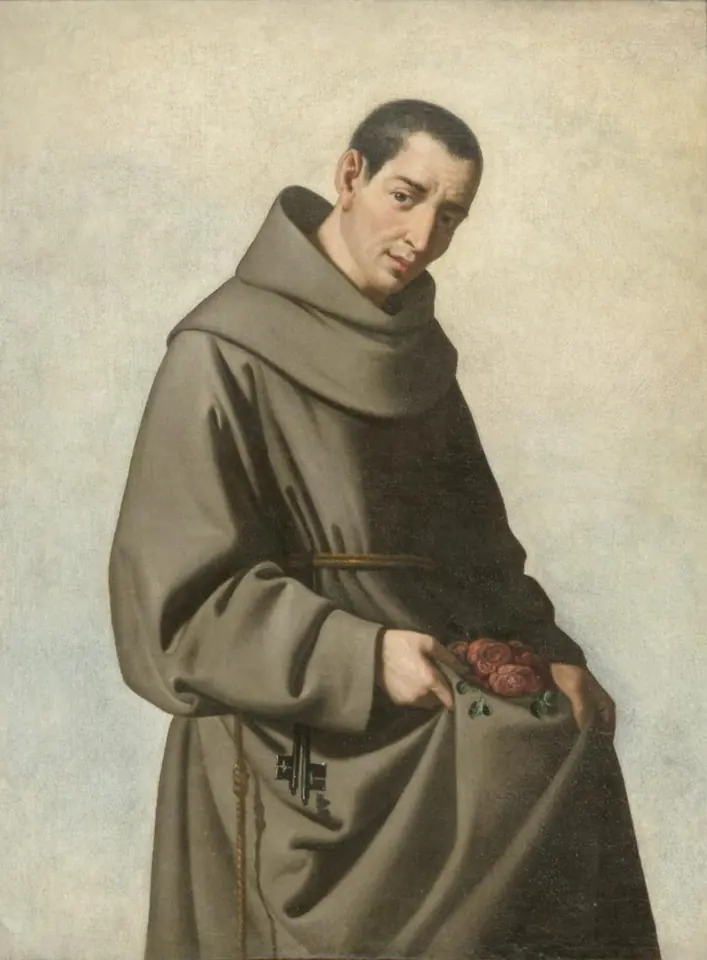 Franciscan friar in a gray-brown habit and cord, his head tilted, holding a fold of his habit filled with red roses against a pale background