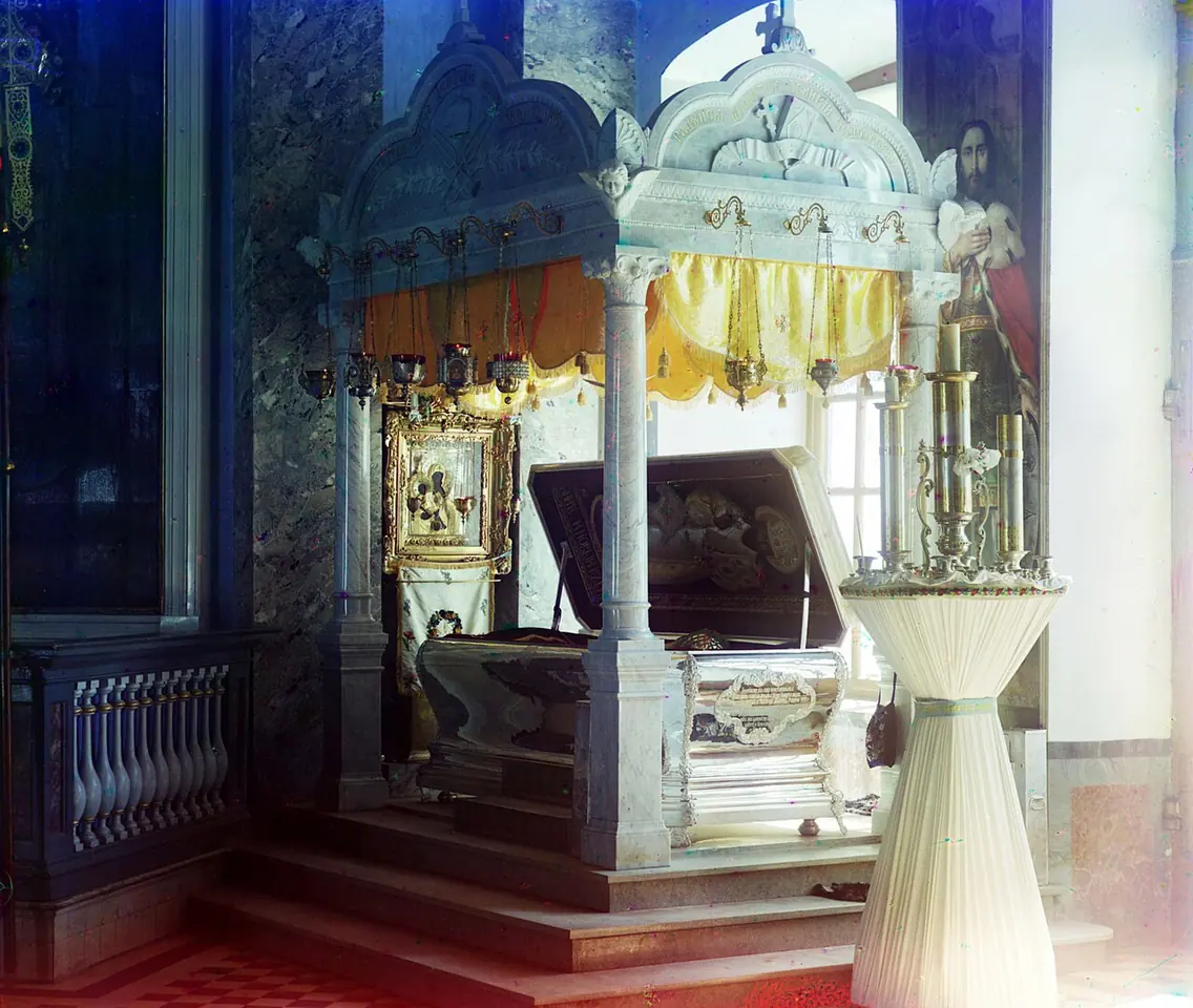 Early color photograph of a church interior with a canopied silver shrine behind a balustrade, with icons and a tall candle stand