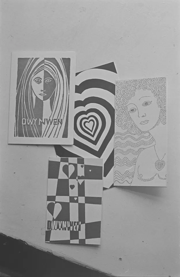Black-and-white photograph of several greeting cards for St. Dwynwen's Day, one with a drawing of a woman's face and the name Dwynwen, others with patterns of hearts