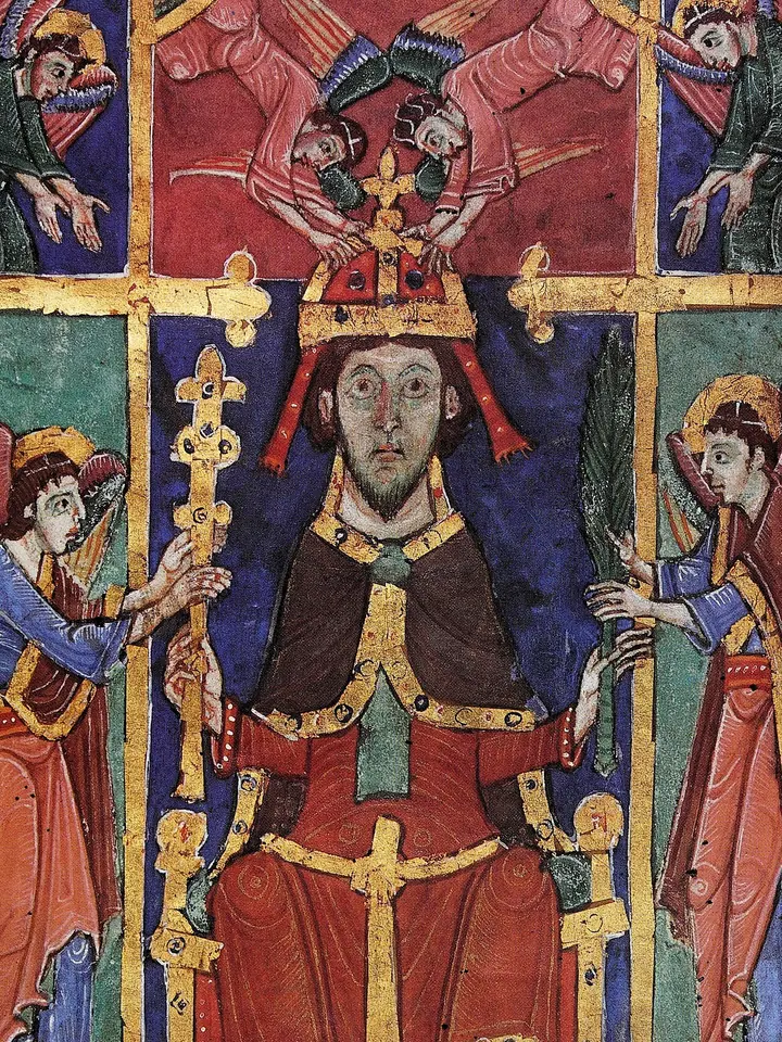 Brightly colored Romanesque manuscript painting of a bearded king enthroned in a red and blue robe with a jeweled crown, holding a scepter, while angels place a second crown on his head