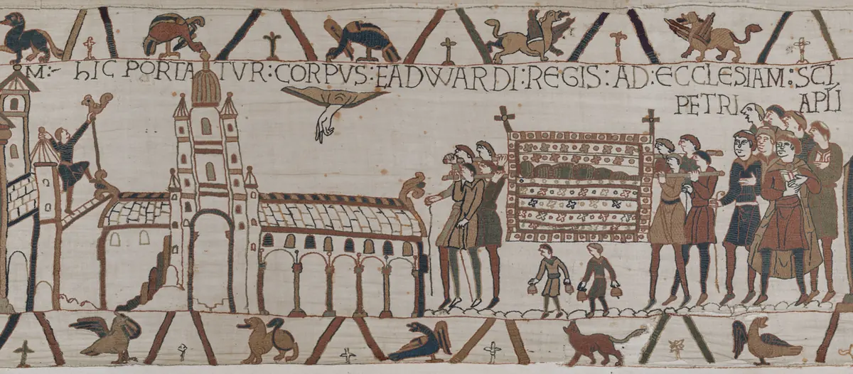 Embroidered scene of men carrying a cloth-covered bier toward a long church with a tower, while a hand reaches down from heaven and a man sets a weathercock on the roof