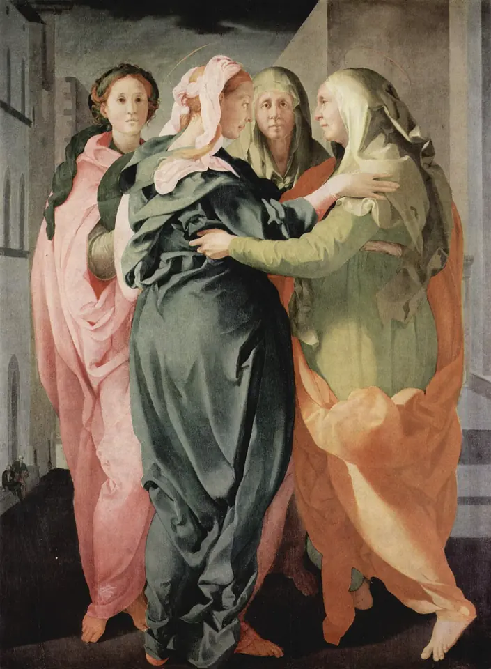 Four tall women in billowing pink, green and orange robes in a city street; an older woman in orange embraces a younger woman in green as two others look out at the viewer
