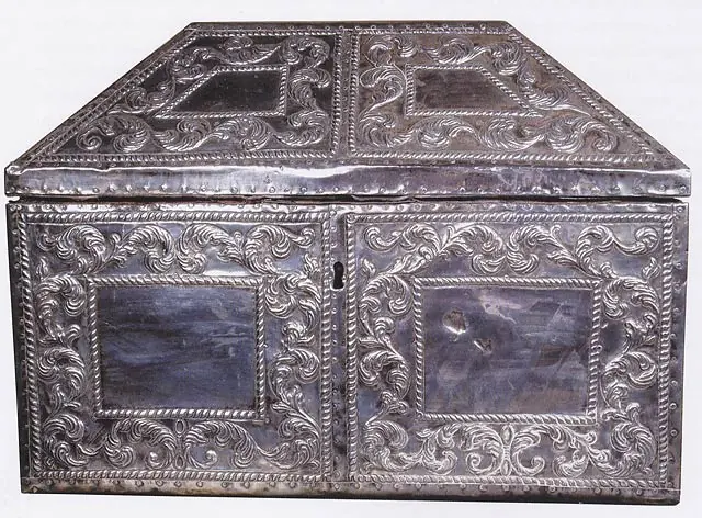 A silver chest with a pitched lid, covered in engraved and embossed scrolling patterns