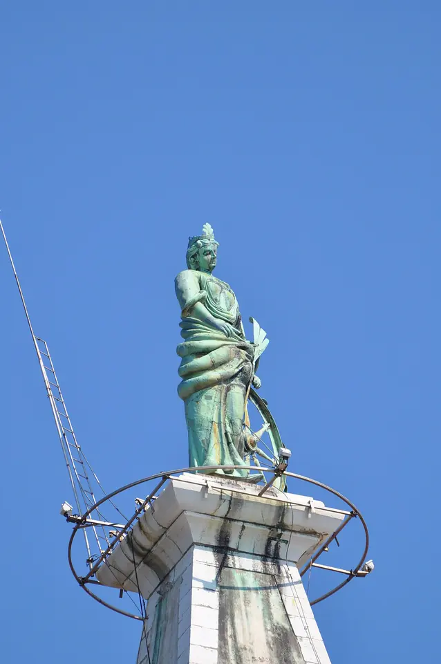 The green copper statue of St. Euphemia turning as a weather vane on top of the bell tower in Rovinj against a clear blue sky