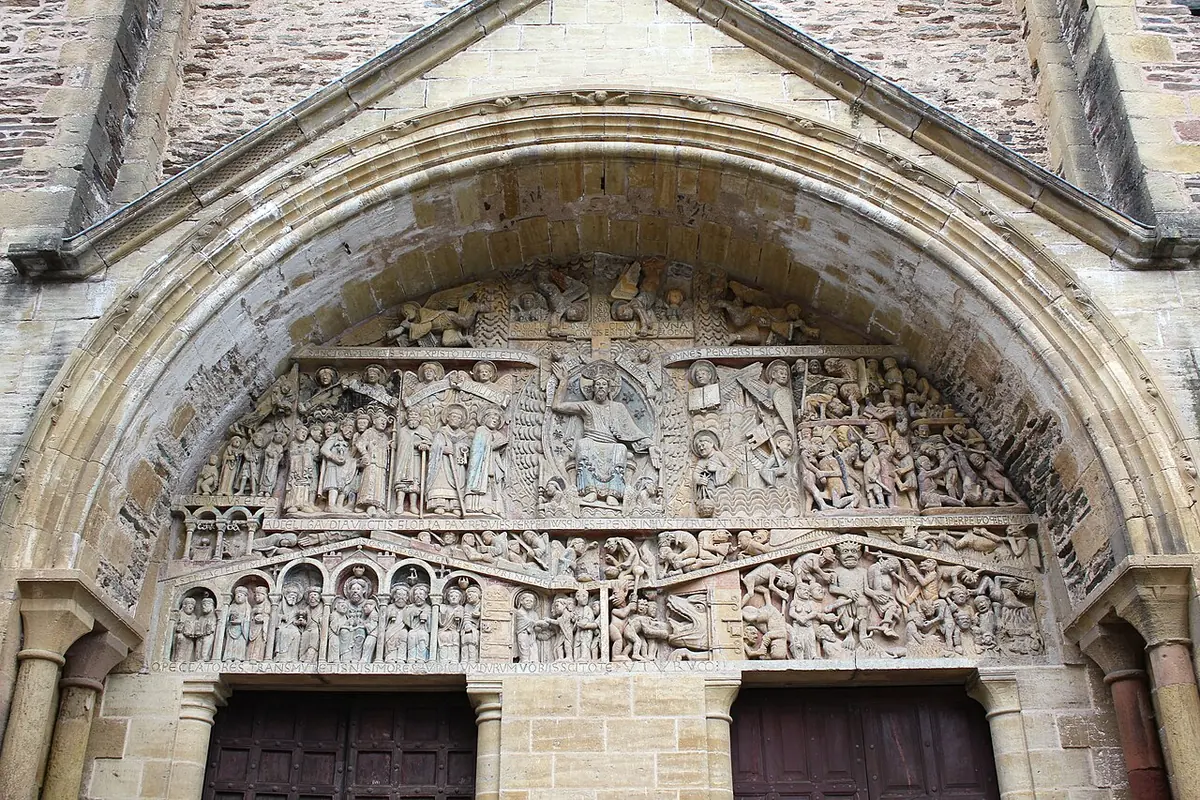 The carved Romanesque Last Judgment over the west door at Conques, with Christ in the center and rows of small figures of the saved and the damned
