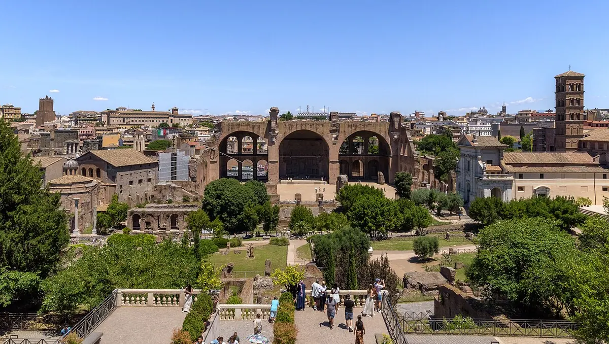 Wide view over the ruins of the Roman Forum to the great brick arches of the Basilica of Maxentius, with the Romanesque bell tower of Santa Francesca Romana on the right