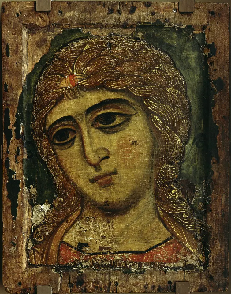 Close-up icon of an angel's face with large dark almond eyes and long golden hair painted in fine gold lines, on a worn wooden panel