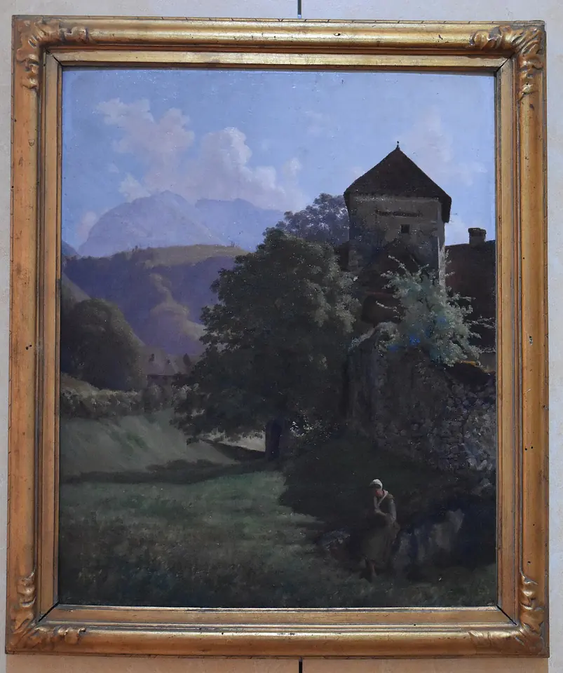 Nineteenth-century oil painting of the old abbey of Talloires, a stone tower and buildings half hidden by trees in a green valley beneath a mountain, in an ornate gold frame