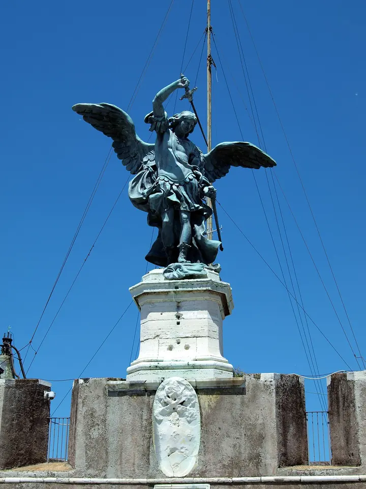 Bronze statue of the Archangel Michael with spread wings sheathing his sword, on top of Castel Sant'Angelo against a blue sky