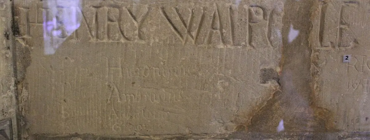 The name HENRY WALPOLE carved in capital letters into the plaster wall of a prison cell, with fainter carved words below