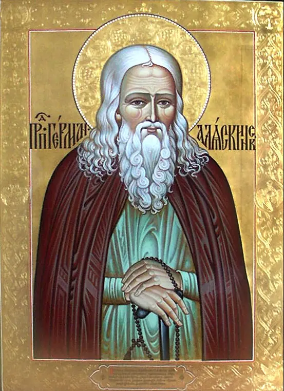 Icon of St. Herman as an old monk with long white hair and beard in a red-brown mantle over a green robe, holding a prayer rope, on a gold background with Slavonic lettering