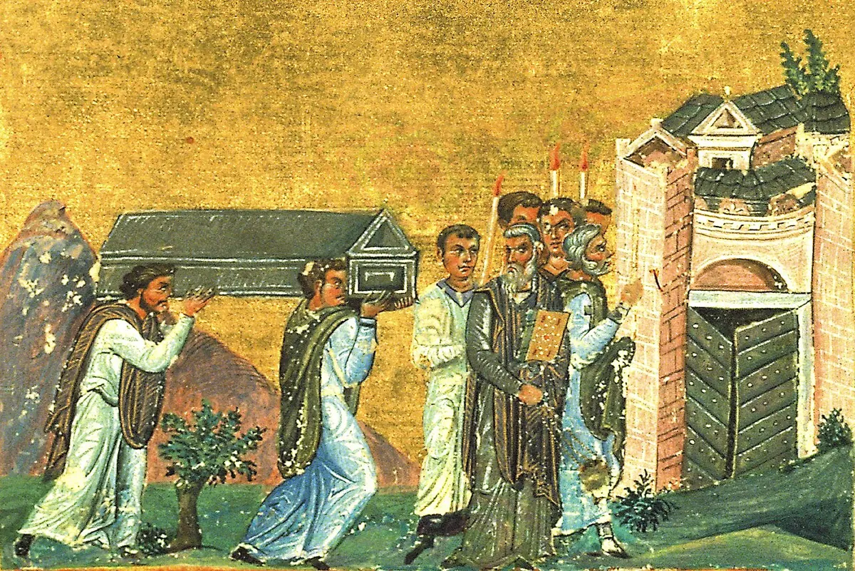 Byzantine manuscript painting of clergy in white robes carrying a reliquary chest on their shoulders toward a walled city gate, with a bishop and people holding candles
