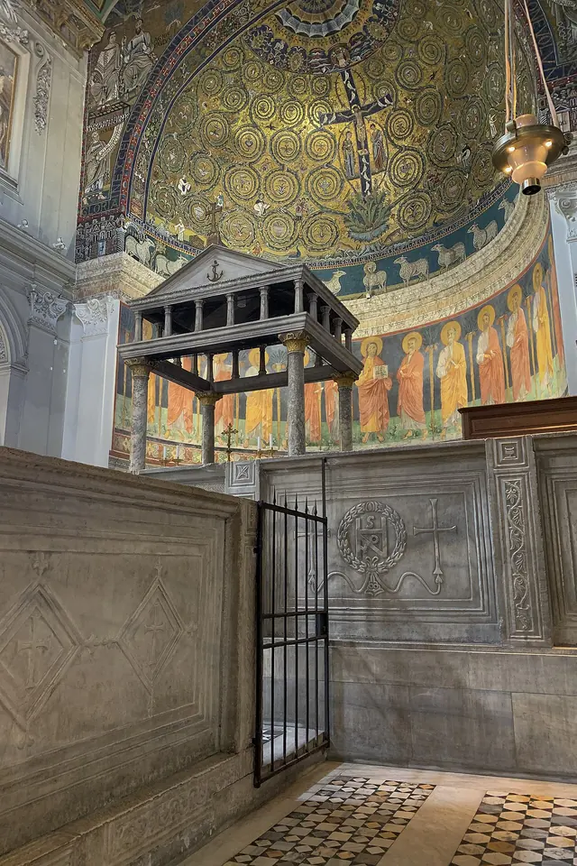The marble choir enclosure and canopied altar of San Clemente in Rome, beneath a gold apse mosaic of a cross growing like a vine