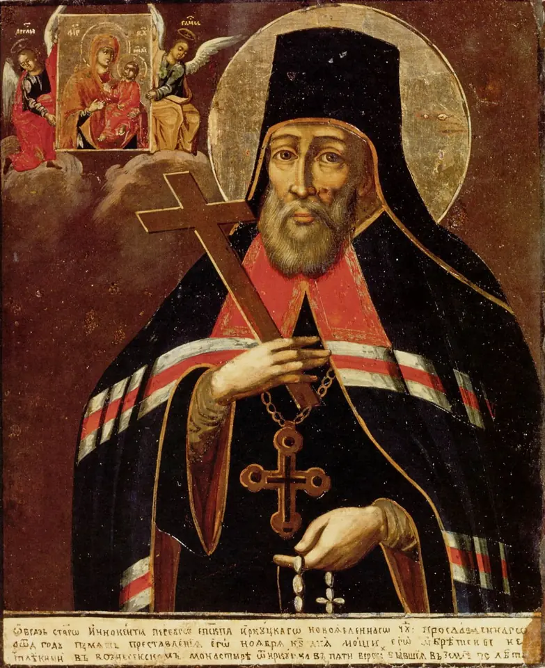 Russian icon of a bishop in a black klobuk and mantle holding a large cross and a prayer rope, with an icon of the Mother of God and angels in the upper corner and a long inscription below