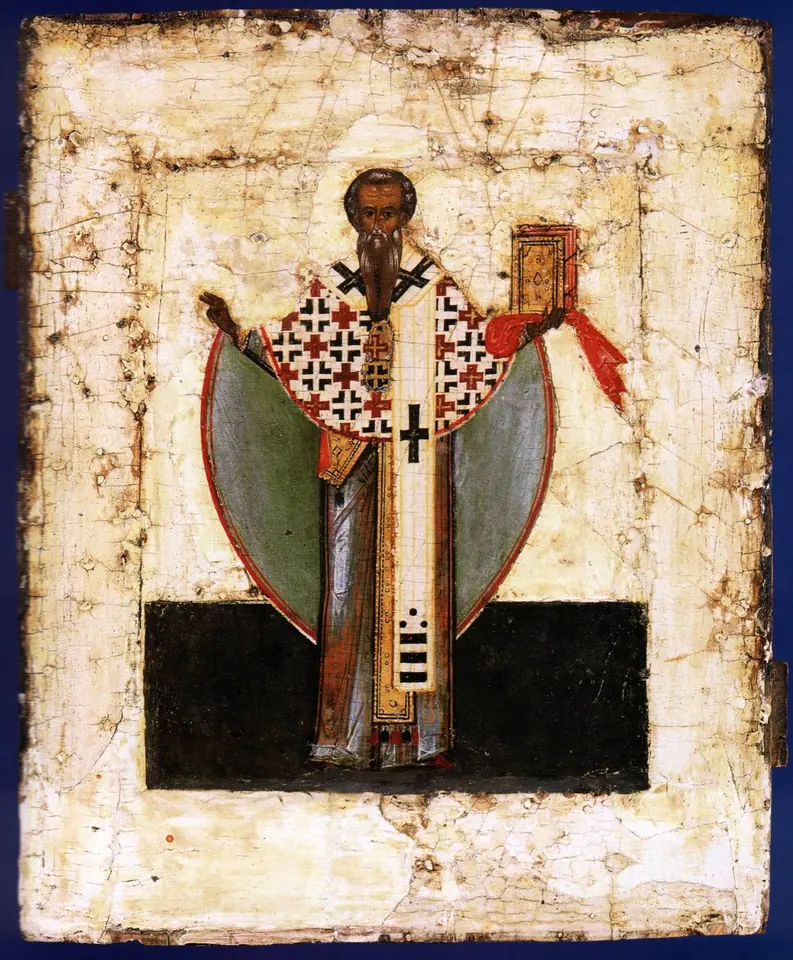 Worn Russian icon of a gray-bearded bishop in a white stole marked with crosses, holding a red book and raising his hand in blessing
