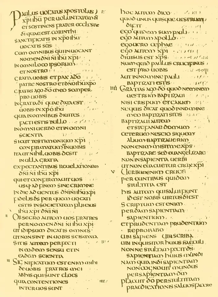 A manuscript page in two columns of large, even Latin capitals in brown ink on pale parchment