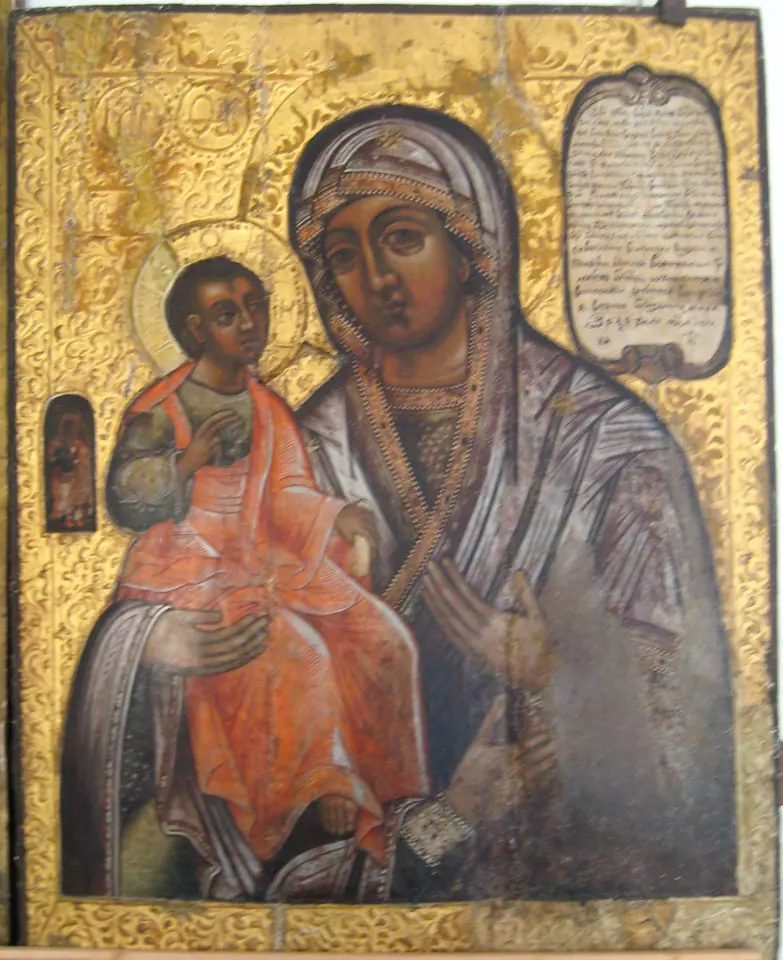Russian icon of the Virgin in a dark mantle holding the Christ Child in a red robe, with a small third hand painted at the bottom of the image
