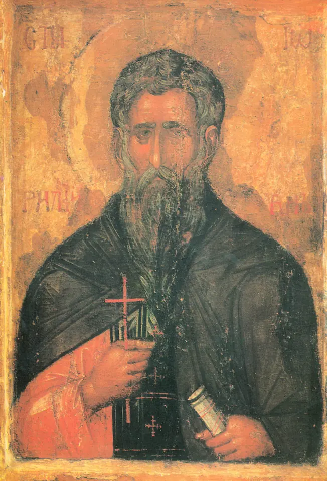 Old icon of a bearded monk with dark hair and a golden halo, wearing a dark habit, holding a small cross and a rolled scroll