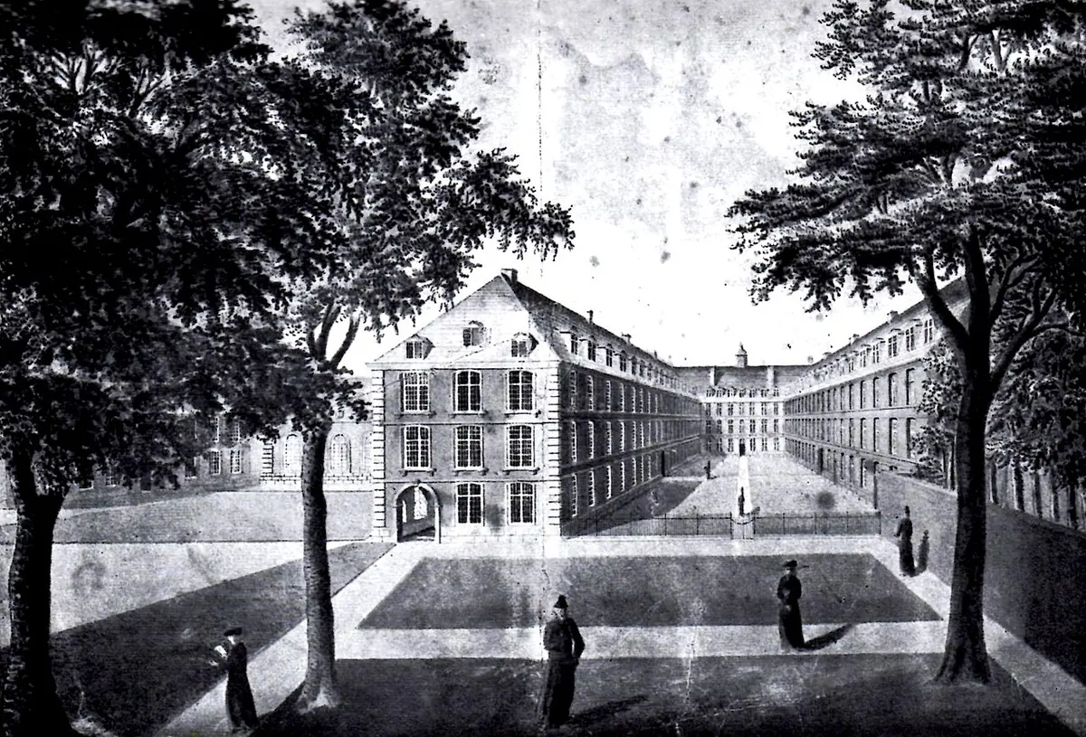 Black-and-white view of a large college courtyard framed by trees, with long multi-story buildings around a lawn and small figures of students in long gowns