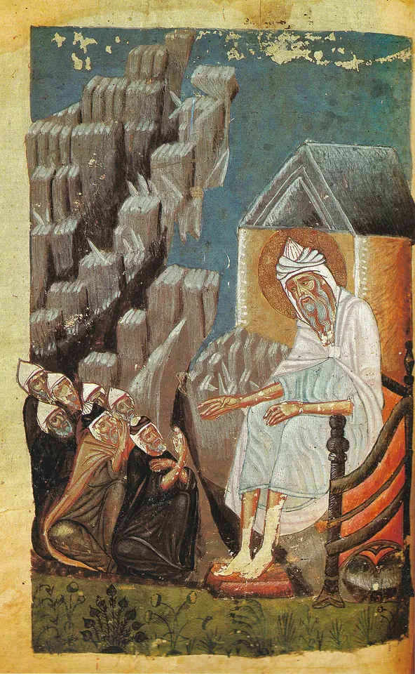 An Armenian manuscript painting of an old white-bearded hermit seated at the door of a small cell among gray rocks, teaching a group of kneeling monks in dark hoods
