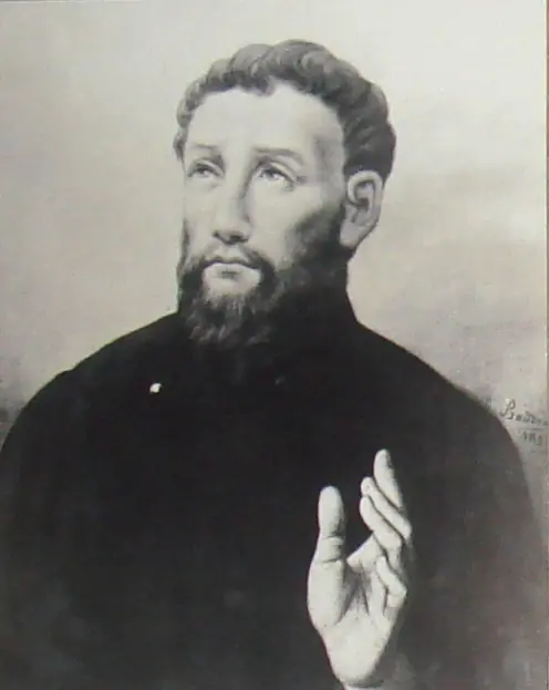 Black-and-white reproduction of a portrait of a bearded young priest in a dark cassock, looking upward and raising his right hand