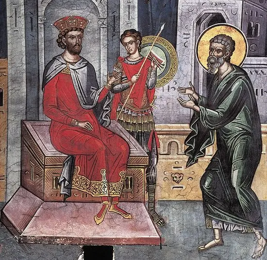 Byzantine fresco of a haloed, bearded man in a green robe with outstretched hands, standing barefoot before a crowned ruler in red seated on a throne, with a soldier holding a spear behind