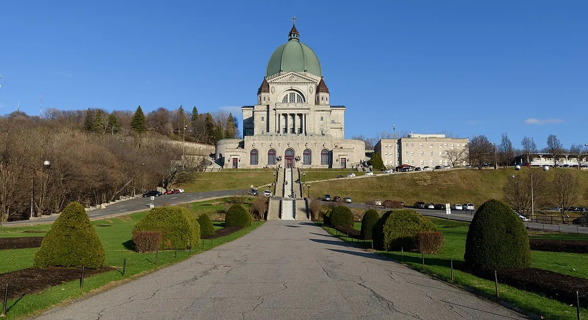 The great green dome of Saint Joseph's Oratory on Mount Royal in Montreal, at the top of long flights of stairs and a tree-lined approach