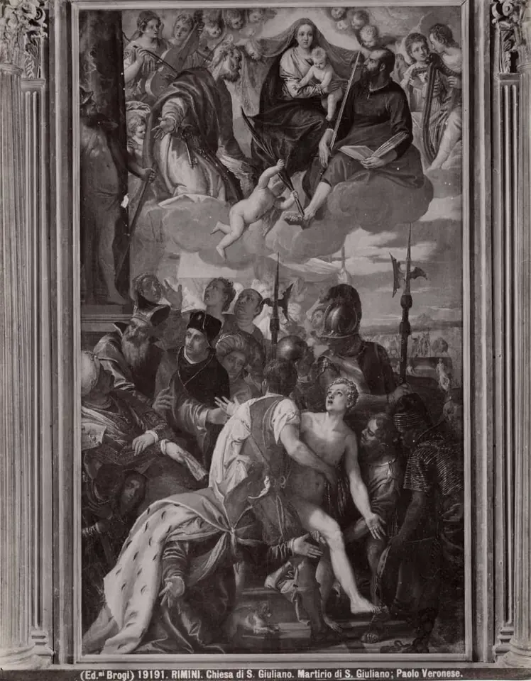 Old black-and-white photograph of a tall altarpiece showing the Virgin and Child in glory above, and below a young man being forced down by soldiers beside a sack