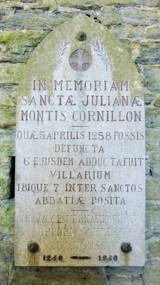 Weathered stone plaque set in a ruined wall with a Latin inscription in memory of St. Juliana of Mont-Cornillon, who died at Fosses on April 5, 1258