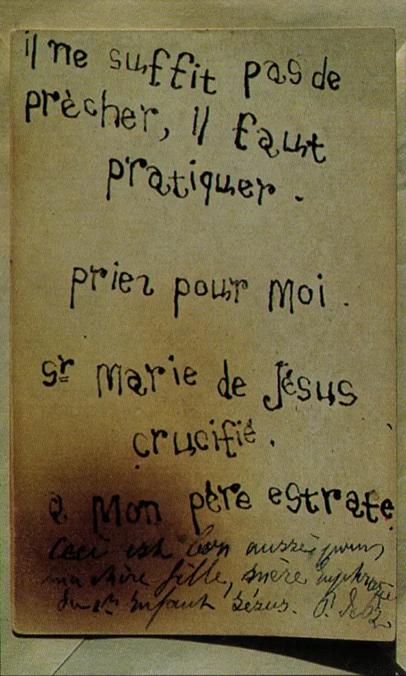 Card with large childlike handwriting in French reading that it is not enough to preach, one must practice, signed Sister Mary of Jesus Crucified