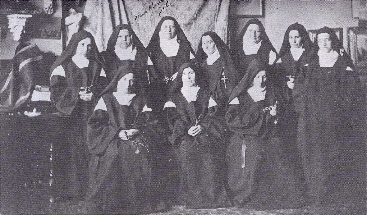 Old group photograph of about a dozen Carmelite nuns in habits and veils, seated and standing, before leaving France for Bethlehem