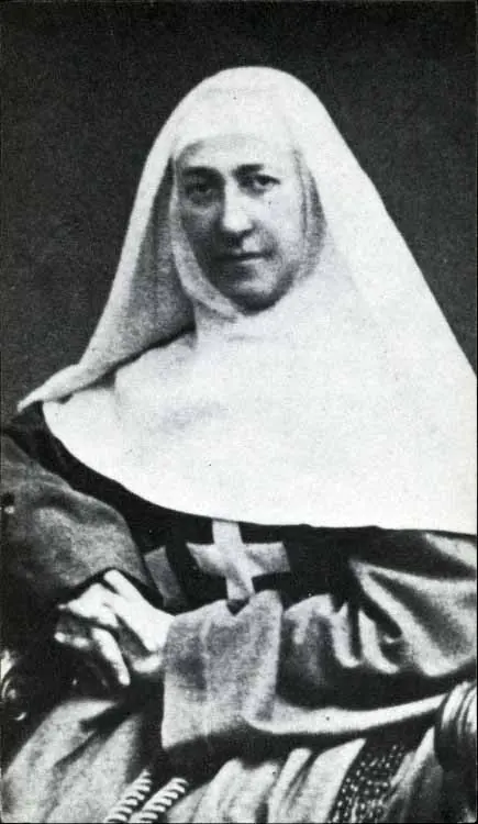 Black-and-white photograph of Mother Marie-Eugénie in a white veil and dark habit with a cross on her breast, seated with her hands folded