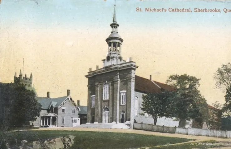 Old colored postcard of a white wooden church with a tall steeple beside a bishop's house and trees, labeled St. Michael's Cathedral, Sherbrooke