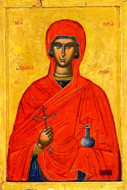 Greek icon of Mary Magdalene wrapped in a bright red veil, holding a small cross in one hand and a glass jar of ointment in the other, against a gold ground