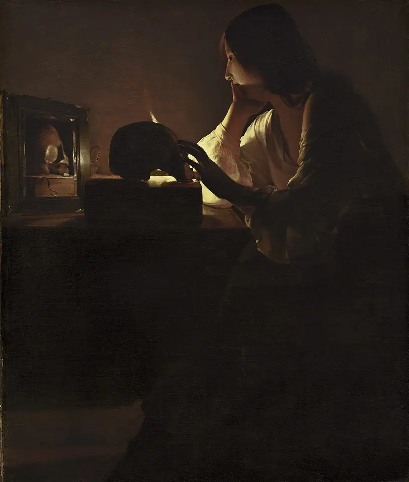 Dark candlelit painting of a young woman in a white blouse seated at a table, resting her hand on a skull and gazing at a candle reflected in a mirror