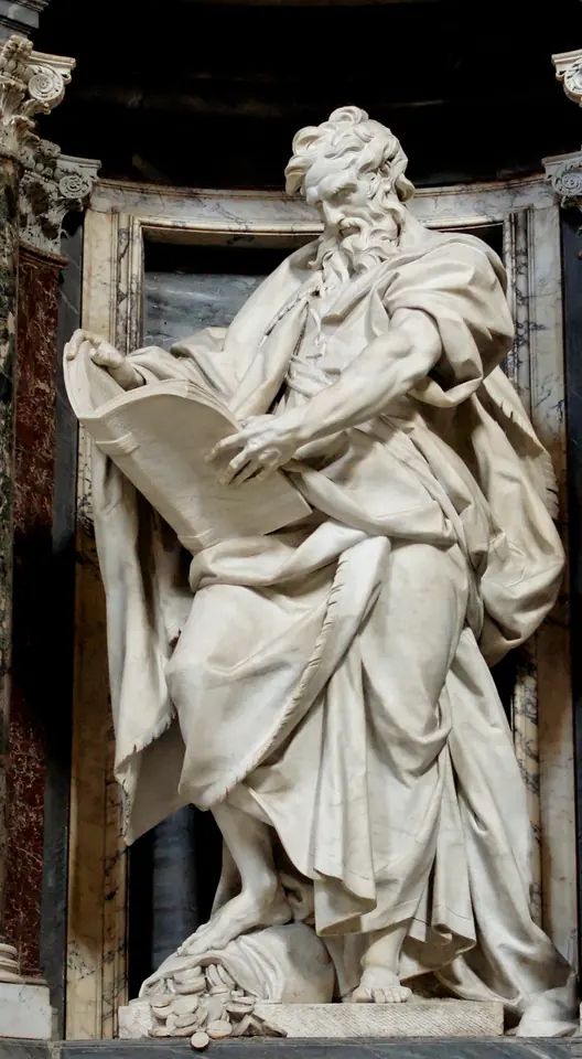 Large white marble statue of a bearded St. Matthew in billowing robes, holding an open book, with a bag of coins at his feet, in a niche of the Lateran Basilica