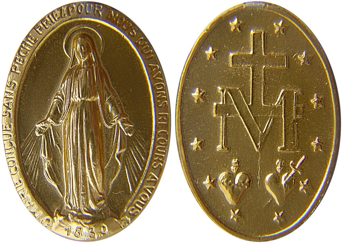 Las dos caras de una medalla ovalada dorada, una con la Virgen María con rayos que salen de sus manos y la otra con una cruz sobre la letra M y dos corazones, rodeados de doce estrellas