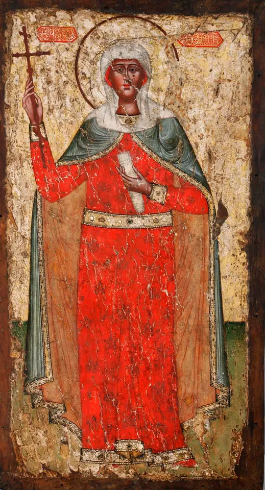 Worn Georgian icon on wood of St. Nino standing full length in a bright red robe and green mantle, a white veil and halo, holding a small cross raised in her right hand