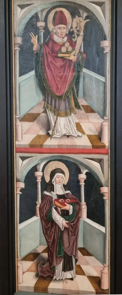 Two painted panels, one above the other, of a bishop with a crozier and, below, an abbess in a red mantle holding a book