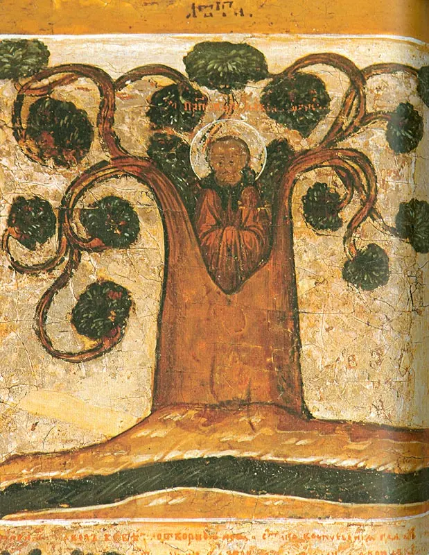 An old icon detail showing a monk standing inside the hollow trunk of a large tree with curling branches and round clumps of leaves